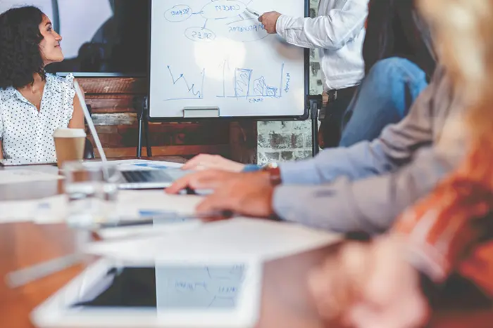 Maritime Marketing. A group discuss maritime marketing around an office boardroom table